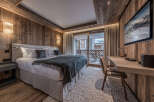 Experience luxury in this stunning bedroom featuring exquisite wood paneling and a cozy ambiance.