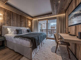 Experience luxury in this stunning bedroom featuring exquisite wood paneling and a cozy ambiance.