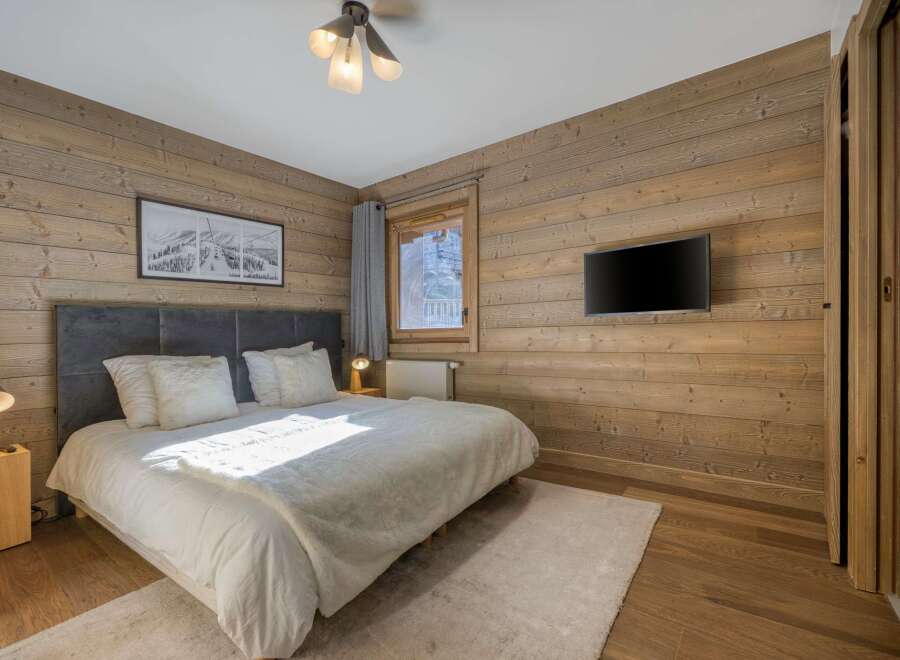 This cozy bedroom features stunning wood paneling that adds warmth and character to the space.