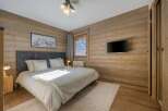 This cozy bedroom features stunning wood paneling that adds warmth and character to the space.
