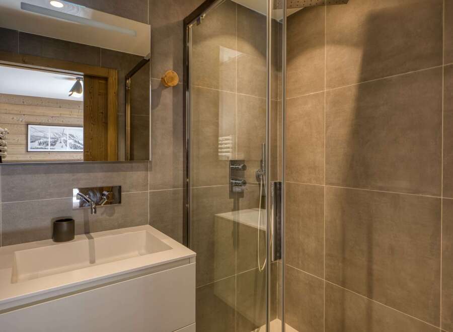 This modern bathroom features a sleek design with a glass shower enclosure and stylish tiling.