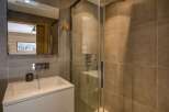 This modern bathroom features a sleek design with a glass shower enclosure and stylish tiling.