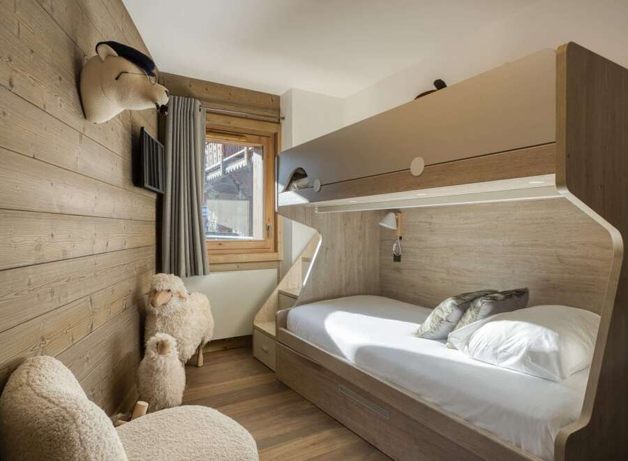 This cozy bedroom features a unique bunk bed design with wooden accents, creating a warm and inviting atmosphere.