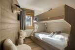 This cozy bedroom features a unique bunk bed design with wooden accents, creating a warm and inviting atmosphere.