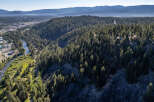 Discover a stunning property nestled in a serene natural setting, surrounded by lush evergreen forests.
