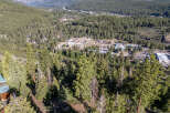 An aerial view showcases a lush, forested landscape, potentially indicating a property with significant natural surroundings.