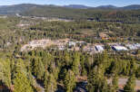 An aerial view showcases a picturesque landscape with lush greenery and a charming town nestled amidst the trees.