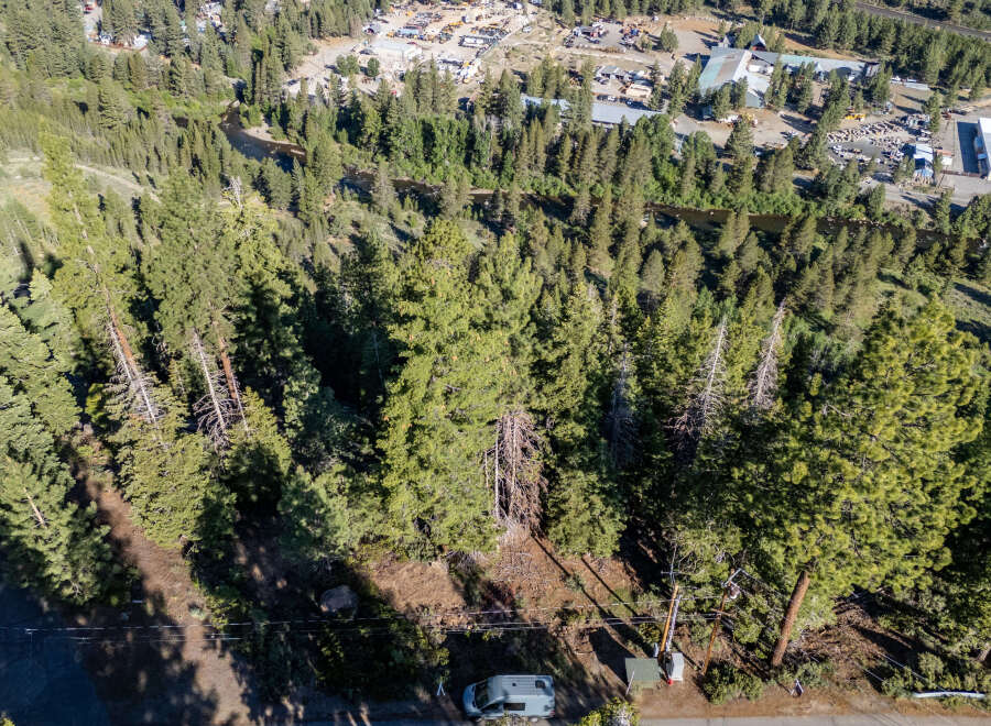 An aerial view showcases a lush, forested landscape, potentially indicating a property with significant natural surroundings.
