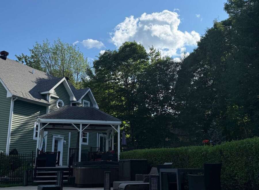 This stunning property boasts a beautifully designed exterior with a charming green facade and a well-maintained roof.