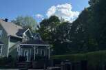 This stunning property boasts a beautifully designed exterior with a charming green facade and a well-maintained roof.