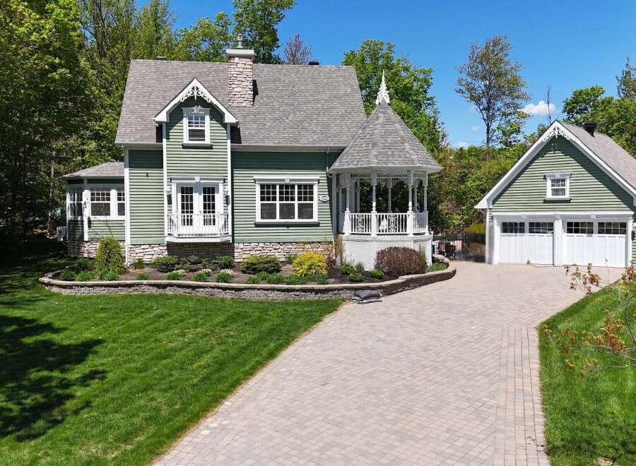 This charming property features a beautifully designed house with a detached garage, offering ample space and functionality.