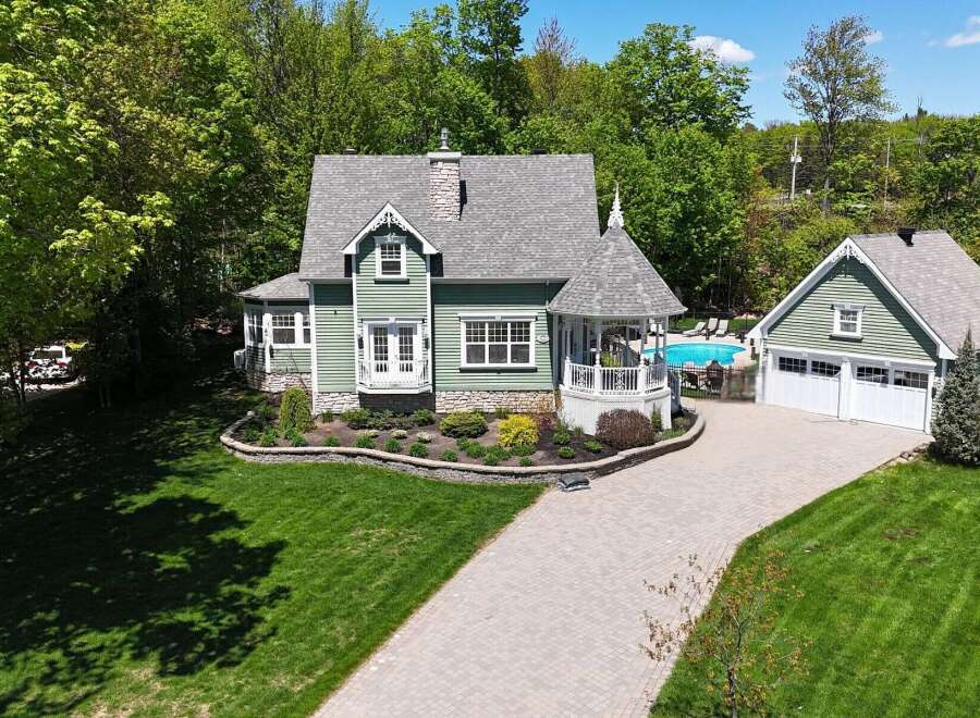 This stunning property boasts a charming green exterior and a beautifully landscaped yard.