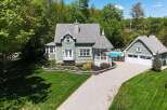 This stunning property boasts a charming green exterior and a beautifully landscaped yard.