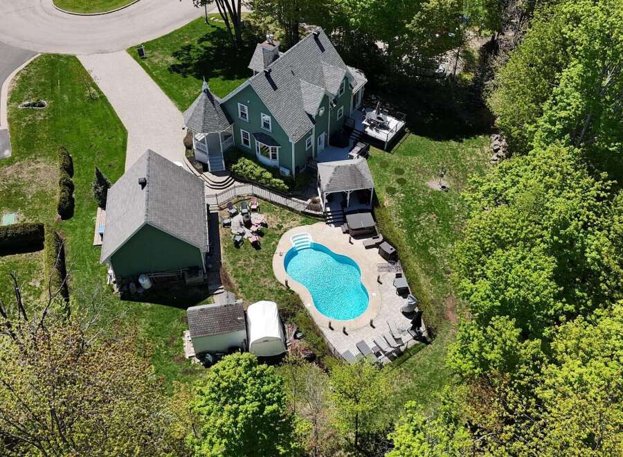 This stunning property boasts a beautiful green exterior and a luxurious pool area, perfect for relaxation and entertaining.