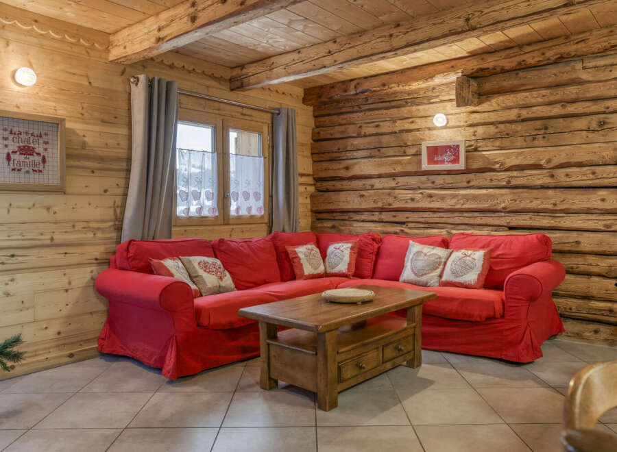 Step into this cozy chalet living room, featuring a vibrant red sectional sofa perfect for relaxing.