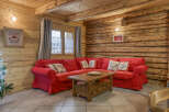 Step into this cozy chalet living room, featuring a vibrant red sectional sofa perfect for relaxing.