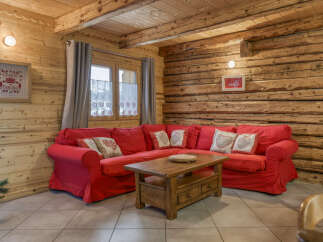 Step into this cozy chalet living room, featuring a vibrant red sectional sofa perfect for relaxing.