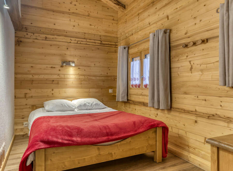 This cozy bedroom features beautiful wooden paneling, creating a warm and inviting atmosphere.