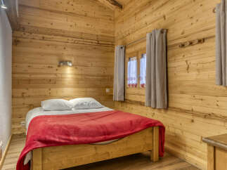 This cozy bedroom features beautiful wooden paneling, creating a warm and inviting atmosphere.