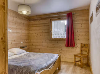 This cozy bedroom features beautiful wooden paneling, creating a warm and inviting atmosphere.
