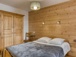 This cozy bedroom features a rustic wooden accent wall that adds warmth and character.