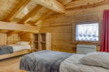 This cozy cabin bedroom features a warm, inviting atmosphere with its wooden walls and ceiling.