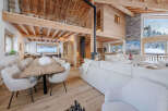 Experience luxury living in this stunning chalet, featuring a spacious open-plan design with exposed wooden beams and a cozy fireplace.