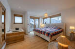 Experience luxury in this stunning bedroom featuring a cozy bed with a vibrant plaid comforter.
