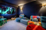 Step into your dream home theater! This cozy space features a large screen perfect for movie nights, plush seating, and playful decor.