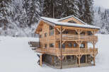 Discover the charm of this stunning wooden chalet nestled in a snowy landscape.