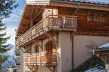 This stunning chalet boasts exquisite wooden balconies and a charming architectural design, perfect for a luxurious mountain retreat.