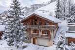 Experience the ultimate winter getaway in this stunning wooden chalet, nestled amidst snow-covered mountains.