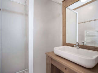 This modern bathroom features a sleek, rectangular sink set atop a rustic wooden vanity.