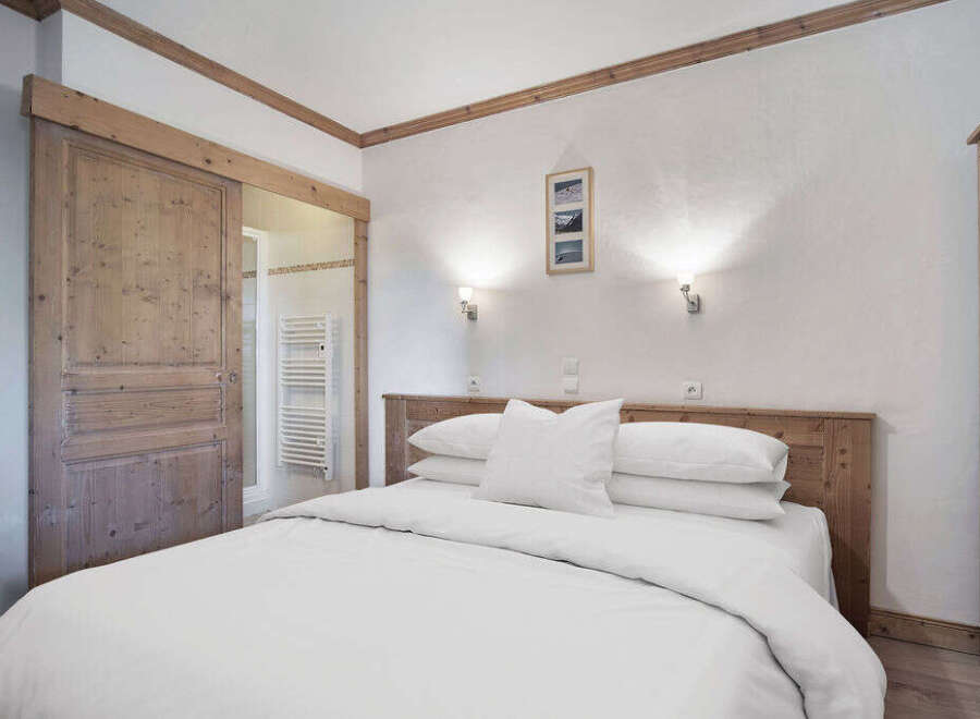 This cozy bedroom features a comfortable bed with crisp white linens, perfect for a relaxing retreat.
