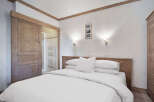 This cozy bedroom features a comfortable bed with crisp white linens, perfect for a relaxing retreat.