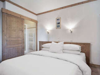 This cozy bedroom features a comfortable bed with crisp white linens, perfect for a relaxing retreat.