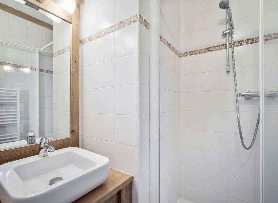 This charming bathroom features a modern sink and a convenient shower.