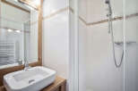 This charming bathroom features a modern sink and a convenient shower.
