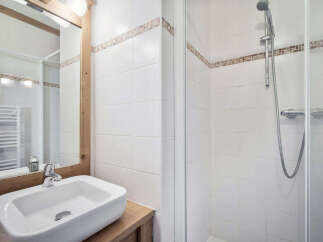 This charming bathroom features a modern sink and a convenient shower.
