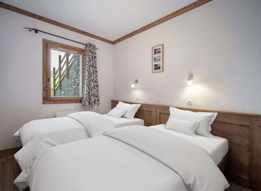 This cozy bedroom features two twin beds with crisp white linens, perfect for a comfortable stay.