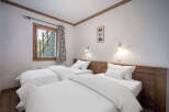 This cozy bedroom features two twin beds with crisp white linens, perfect for a comfortable stay.