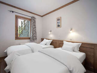 This cozy bedroom features two twin beds with crisp white linens, perfect for a comfortable stay.