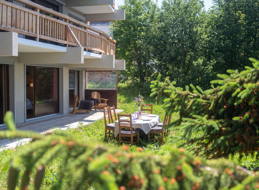 Enjoy al fresco dining on this charming patio, complete with a table set for a meal and comfortable seating.