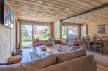 Experience luxury mountain living in this stunning chalet, featuring a spacious open-plan living area with a cozy fireplace and large windows offering breathtaking views.