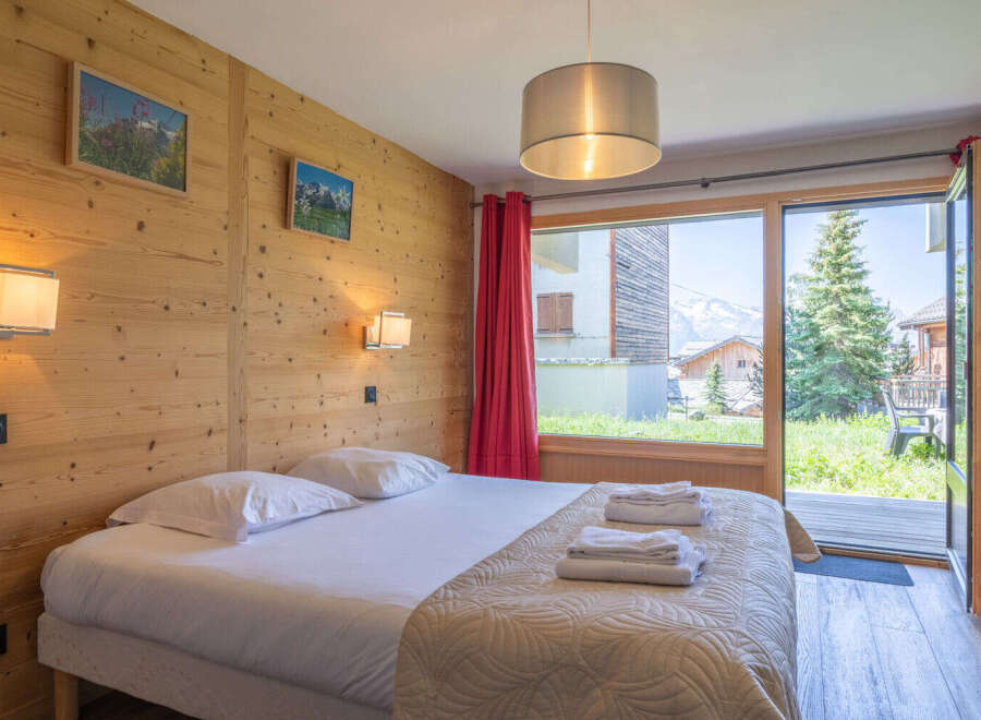 Experience cozy mountain living in this charming bedroom featuring a comfortable bed adorned with plush linens and a quilted throw.