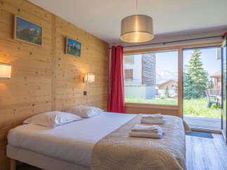 Experience cozy mountain living in this charming bedroom featuring a comfortable bed adorned with plush linens and a quilted throw.