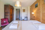 Experience cozy mountain living in this charming bedroom, featuring a plush velvet armchair and a large wooden wardrobe.
