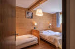 This charming bedroom features warm wooden walls and a cozy ambiance, perfect for a relaxing retreat.