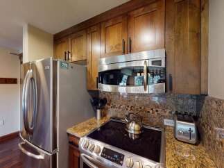 This stunning kitchen boasts modern appliances and elegant wooden cabinetry, perfect for culinary enthusiasts.