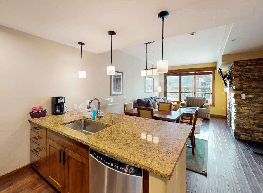 This stunning kitchen features a granite countertop, stainless steel appliances, and modern pendant lighting, perfect for preparing meals and entertaining guests.